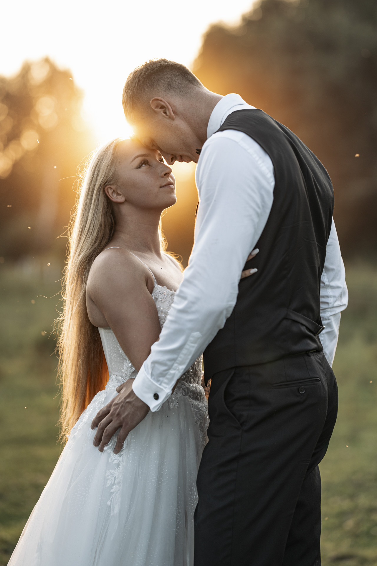 Fotograf ślubny Chorzów – para młoda podczas romantycznej sesji w pełnym słońcu na zielonej polanie.