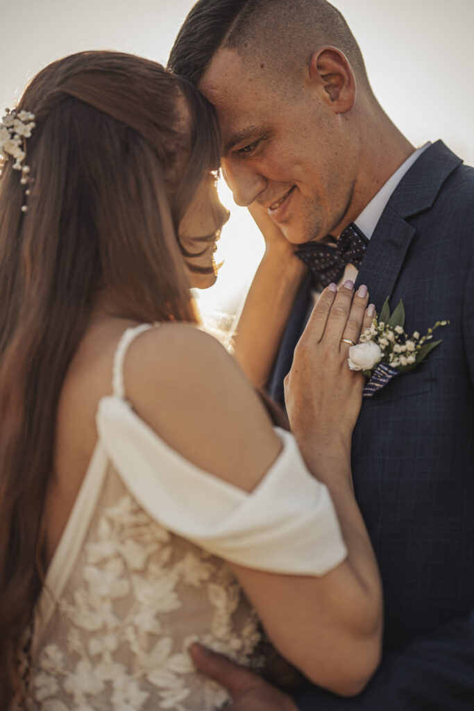 Fotograf ślubny Ruda Śląska – bliskie, pełne emocji ujęcie pary młodej stykającej się czołami w świetle zachodzącego słońca.