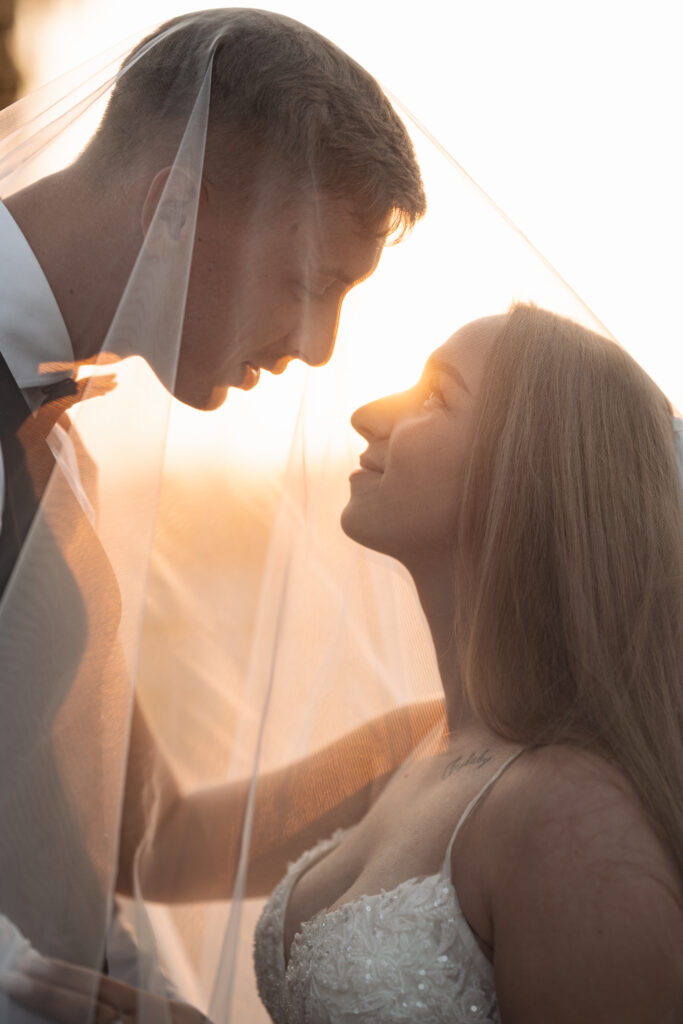 Sesja ślubna Świętochłowice – romantyczny portret pary młodej pod welonem w promieniach zachodzącego słońca.