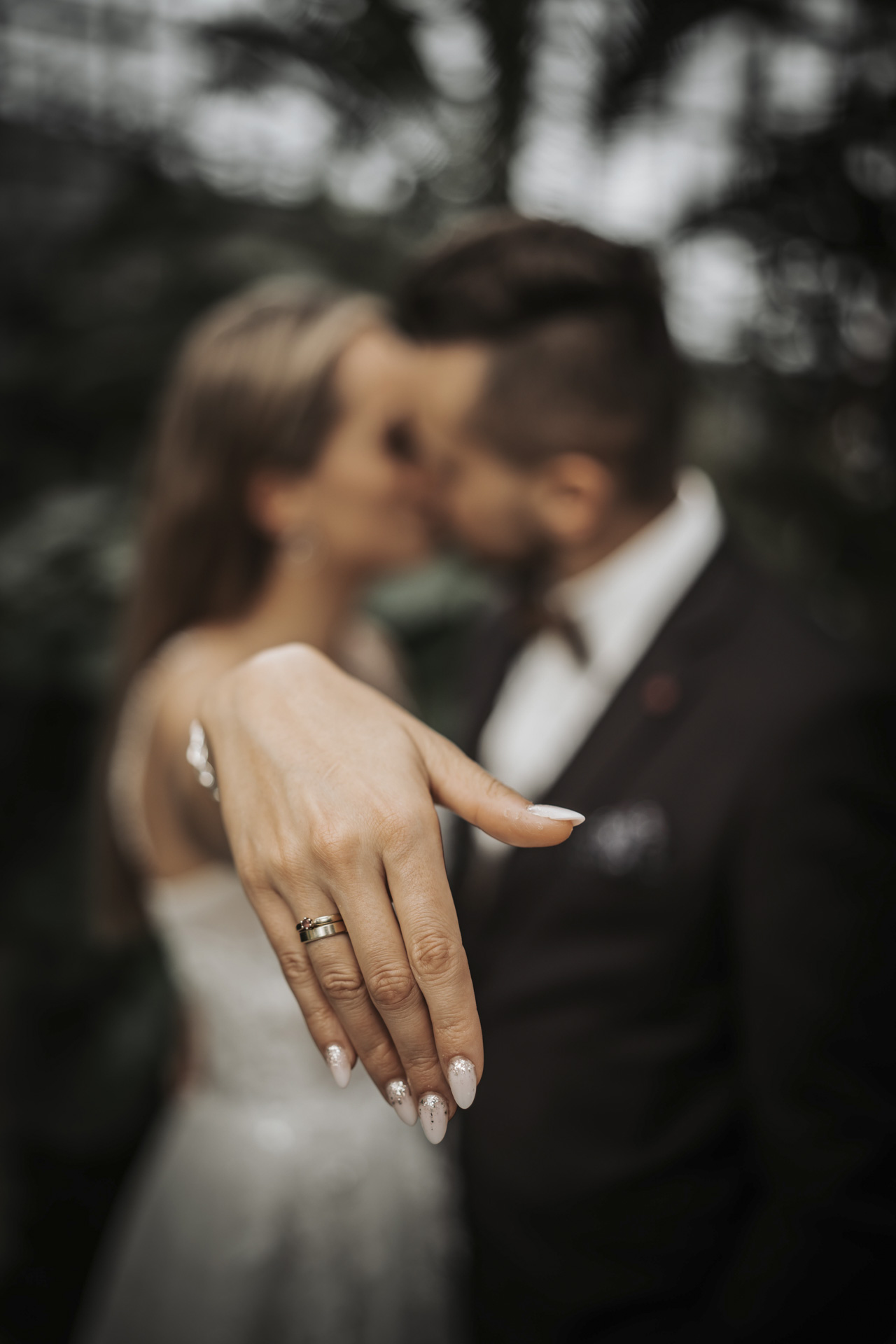 Fotografia ślubna Zabrze – zbliżenie na splecione dłonie pary młodej prezentujące złote obrączki ślubne.