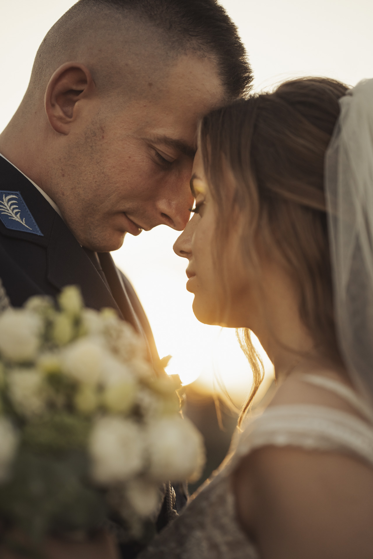 Fotograf ślubny Zabrze – nastrojowy portret pary młodej stykającej się czołami w świetle zachodzącego słońca.