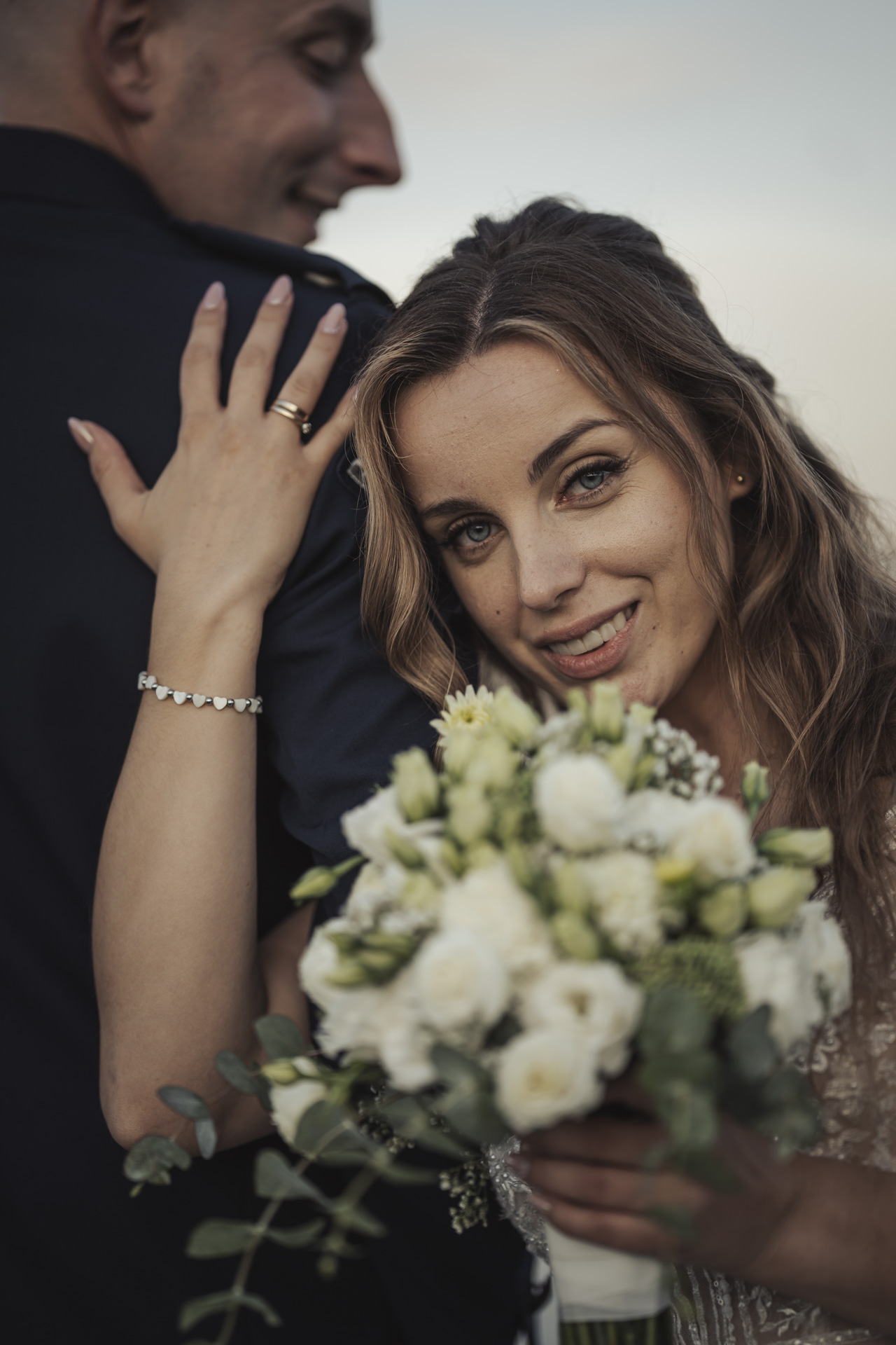 Fotografia ślubna Bytom – portret uśmiechniętej panny młodej z bukietem kwiatów podczas sesji w plenerze.