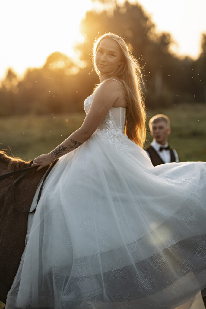 Fotografia ślubna Jaworzno – portret panny młodej w białej sukni na tle zachodzącego słońca.