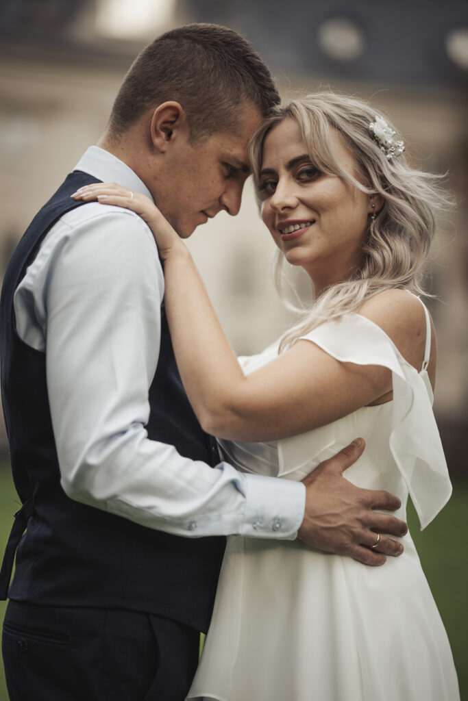 Kamerzysta na wesele Chorzów – elegancki portret panny młodej z panem młodym w tle.