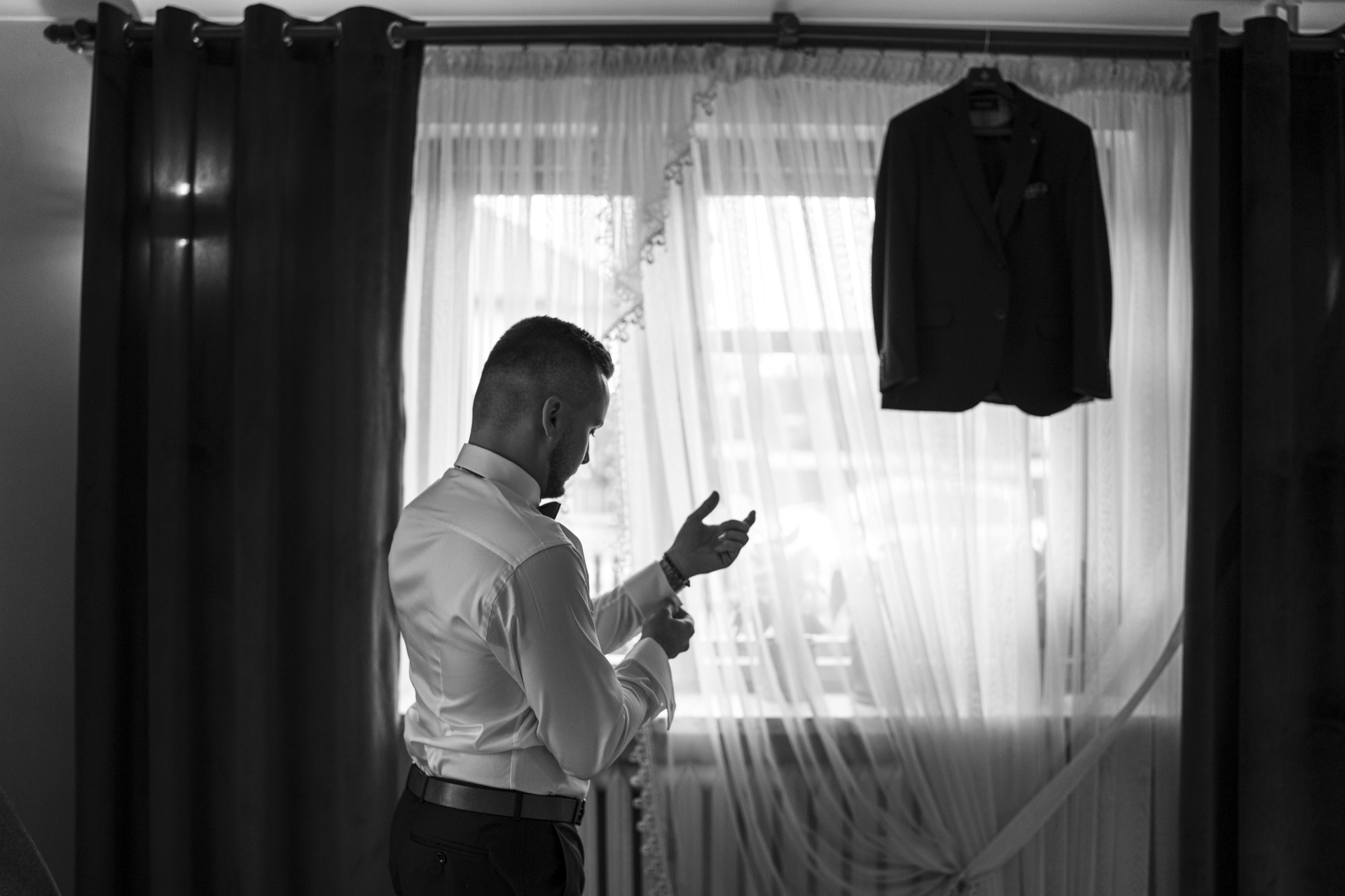 Fotograf na ślub Sosnowiec – nastrojowe ujęcie przygotowań pana młodego w nastrojowym świetle.