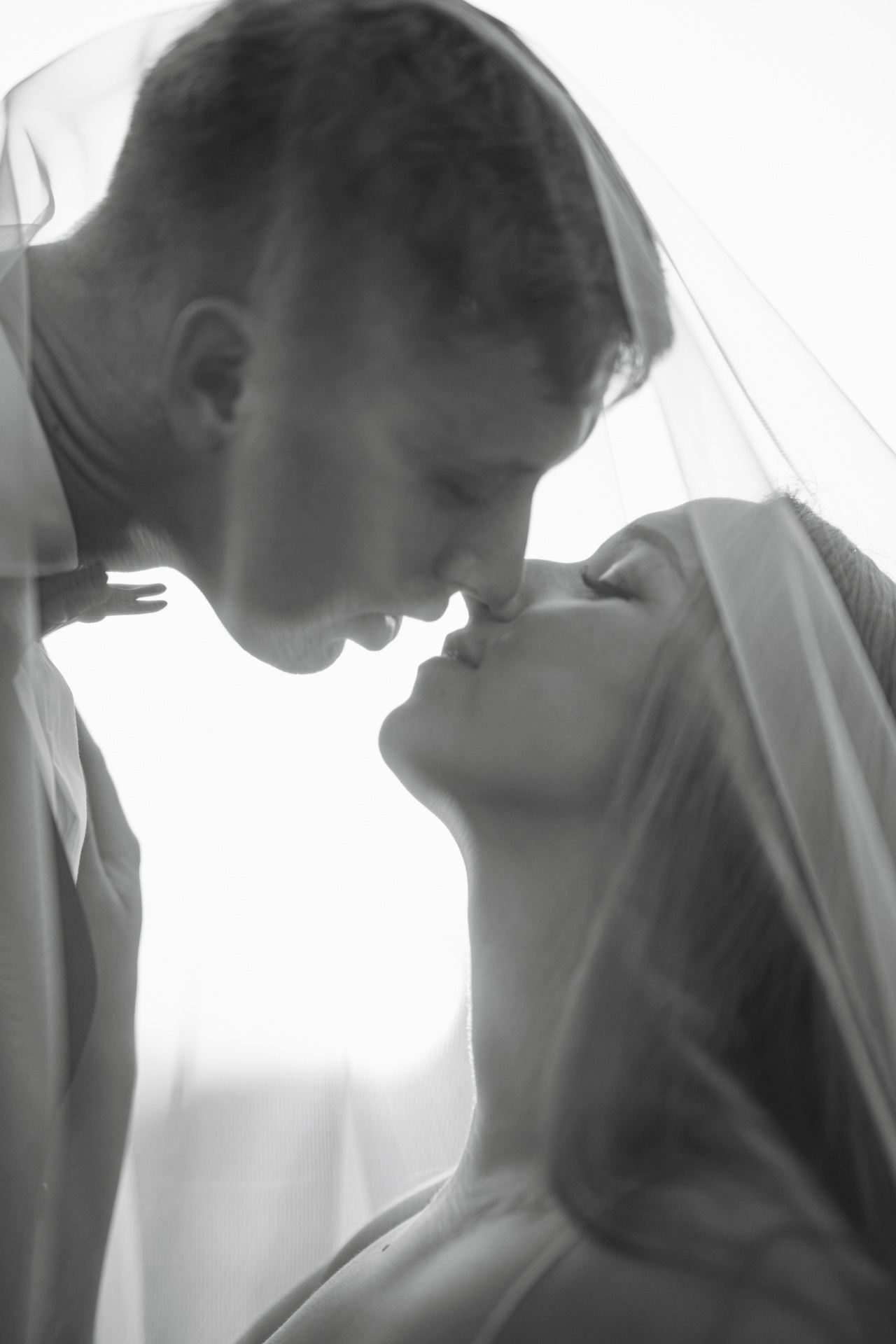 Reportaż ślubny Bytom – czarno-białe, artystyczne ujęcie panny młodej pod welonem w obiektywie fotografa.